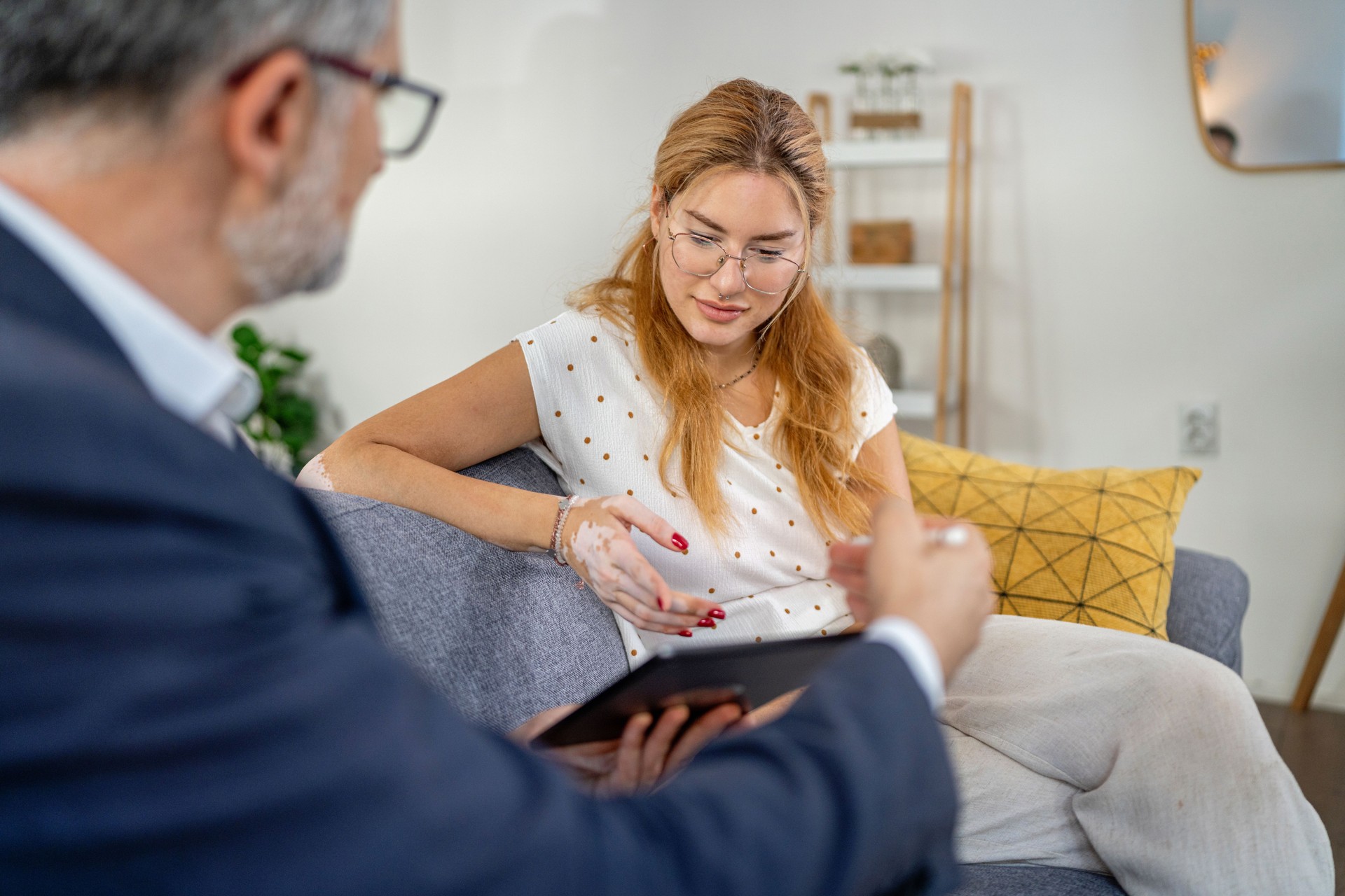 The advisor demonstrates financial options via tablet while the client watches intently.